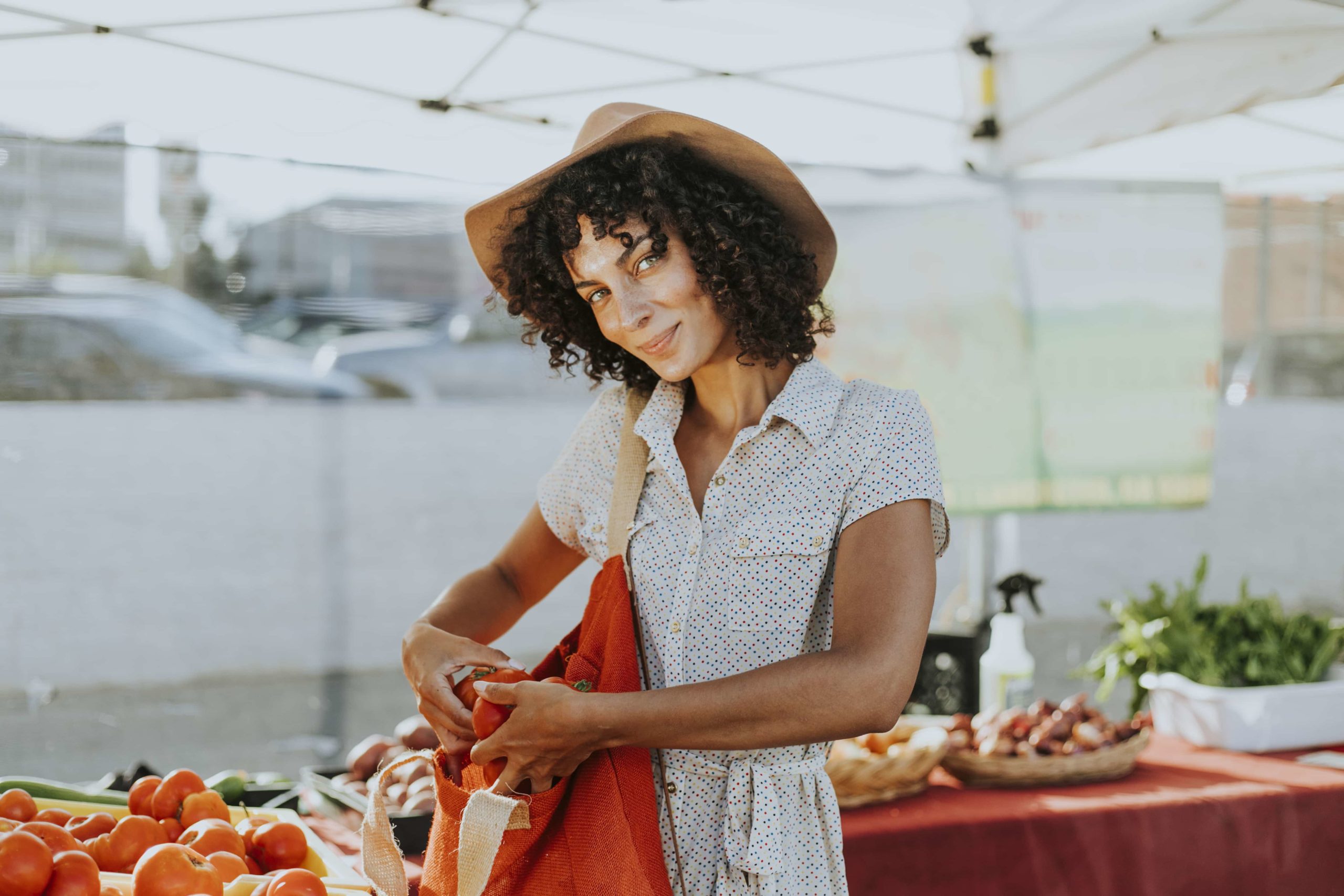 A woman at a farmer’s market grabbing vegetables and expressing her true self.